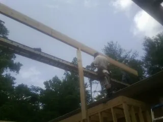 Carpenter setting a ridge beam over a new addition frame — Ice Dam Removal by Roofing Brothers in Meade