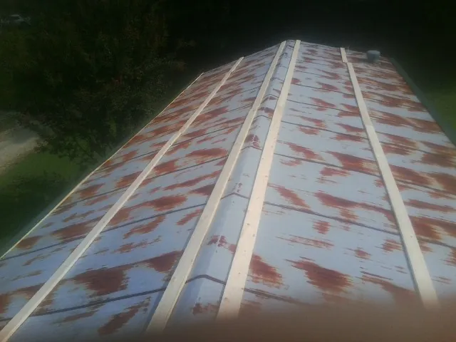 Rusted metal roof panels with new wood purlins before replacement — Storm Damage Roof Repair in Meade by Roofing Brothers