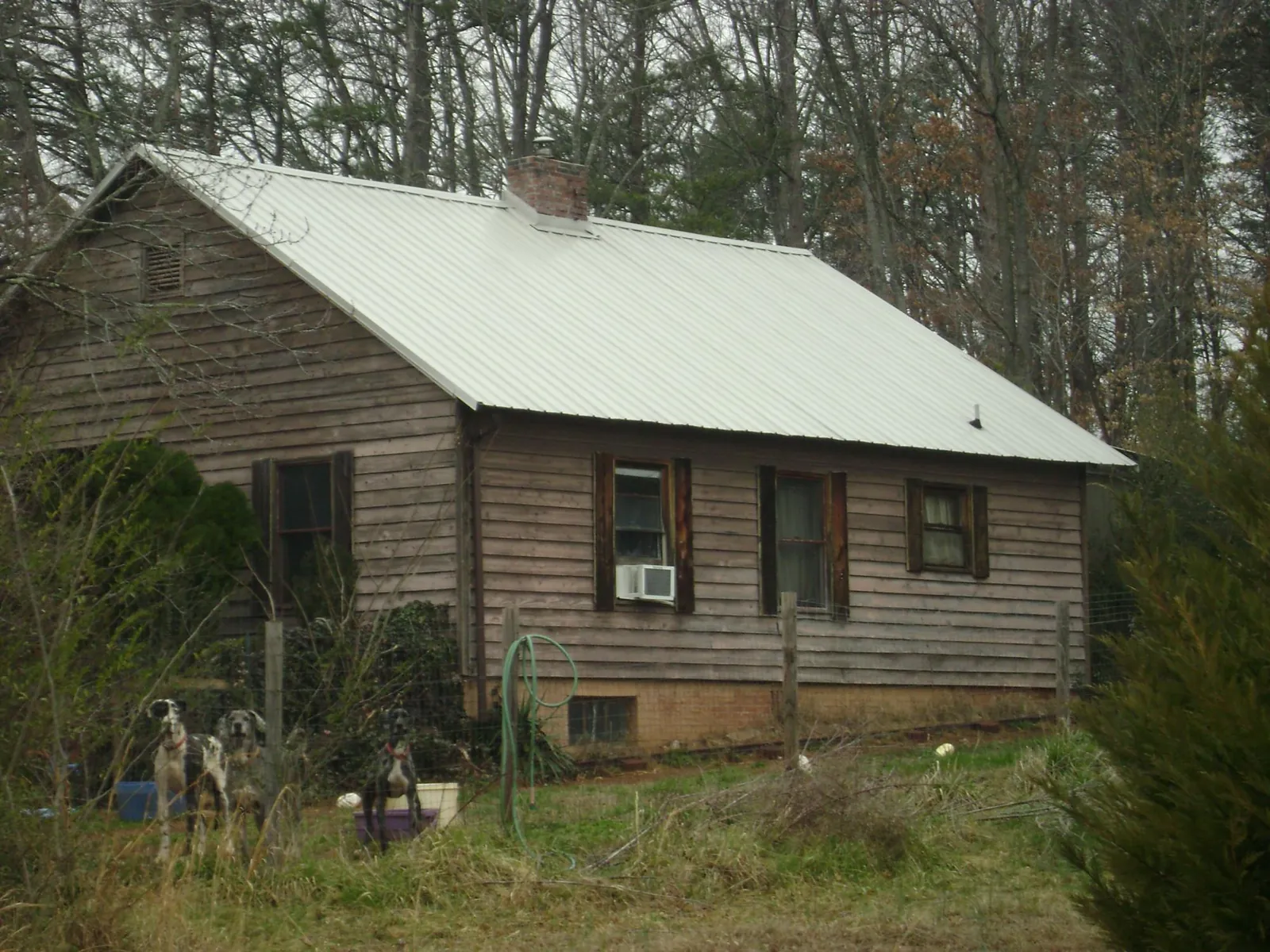 White metal roof on an old wood sided farmhouse, from a Metal Roof Installation job in Meade